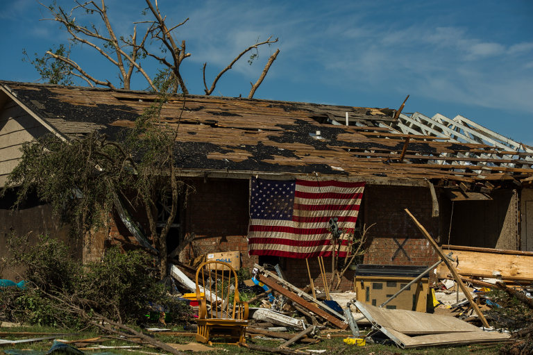 Destroyed house with American flag