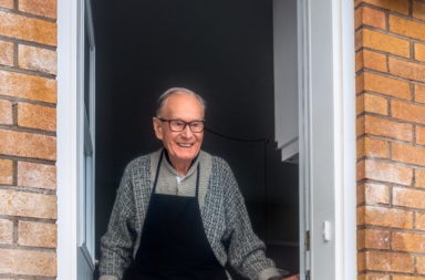 older man greeting in door
