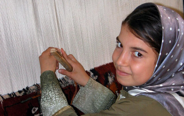Girl weaving rug