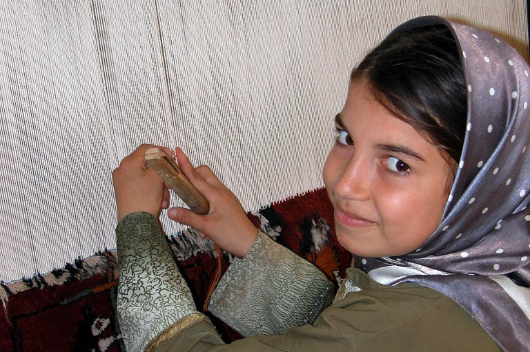 Girl weaving rug
