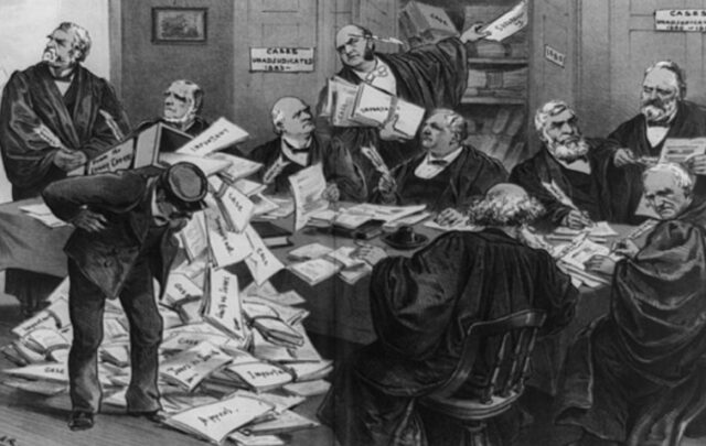 Supreme Court justices around a table, struggling to keep up with an overload of cases piling up on the floor (1885)
