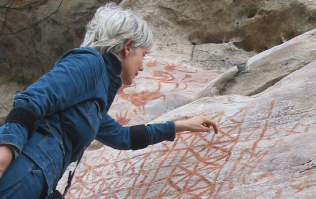 Anna Roosevelt looking at imagery at the Painted Rock Cave near Monte Alegre dating back to 11,000 BCE. Image courtesy of Anna Roosevelt.