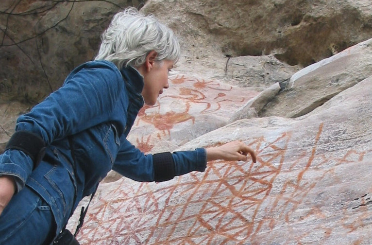 Anna Roosevelt looking at imagery at the Painted Rock Cave near Monte Alegre dating back to 11,000 BCE. Image courtesy of Anna Roosevelt.