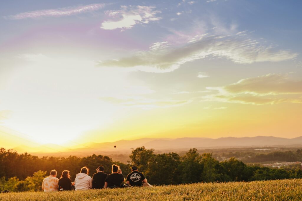 People sitting in a field, via Unsplash