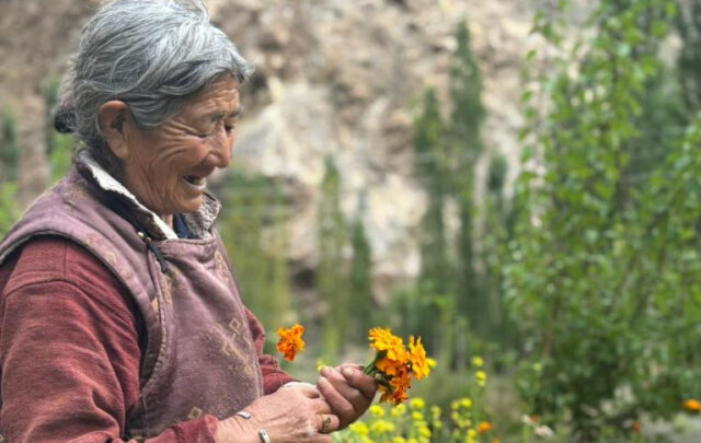 Woman holding flowers in Ladakh