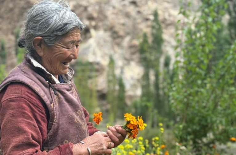 Woman holding flowers in Ladakh