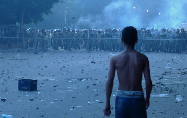 “A Boy Confronts Egyptian Military Police South of Tahrir Square - A Potentially Tragic Disparity of Power and Equipment.” by Alisdare Hickson, CC BY-SA 2.0