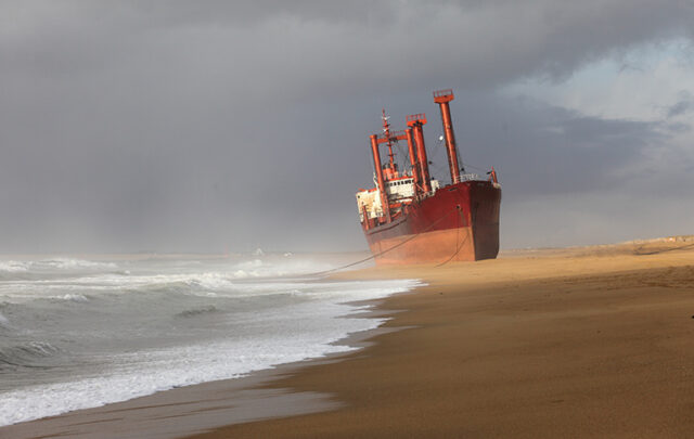 A large cargo ship stranded on a beach.